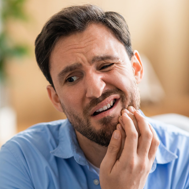 man-discomfort-is-seated-couch-holding-his-face-pain-due-toothache-his-expression